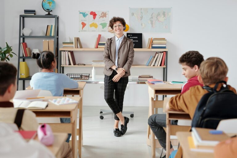 A teacher and her students in a classroom in the concept of top schools in Leyton.