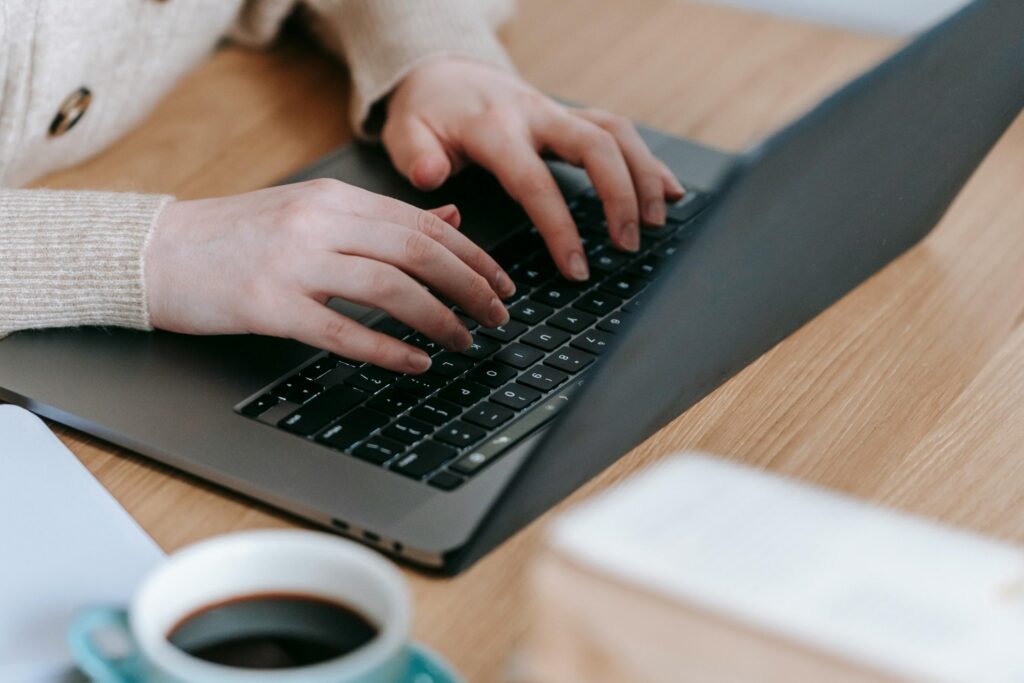 A woman is booking a man and van service through her laptop.