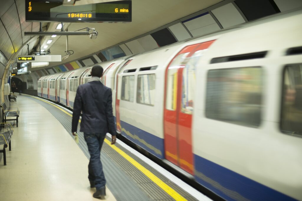 A man is walking at an underground train station