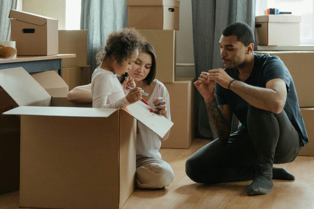 A young family in their house surrounded by cardboard in the concept of saving money for moving to Leyton.